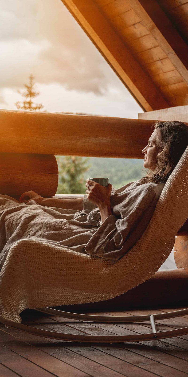 A woman enjoying a mountainous sunset from her condo