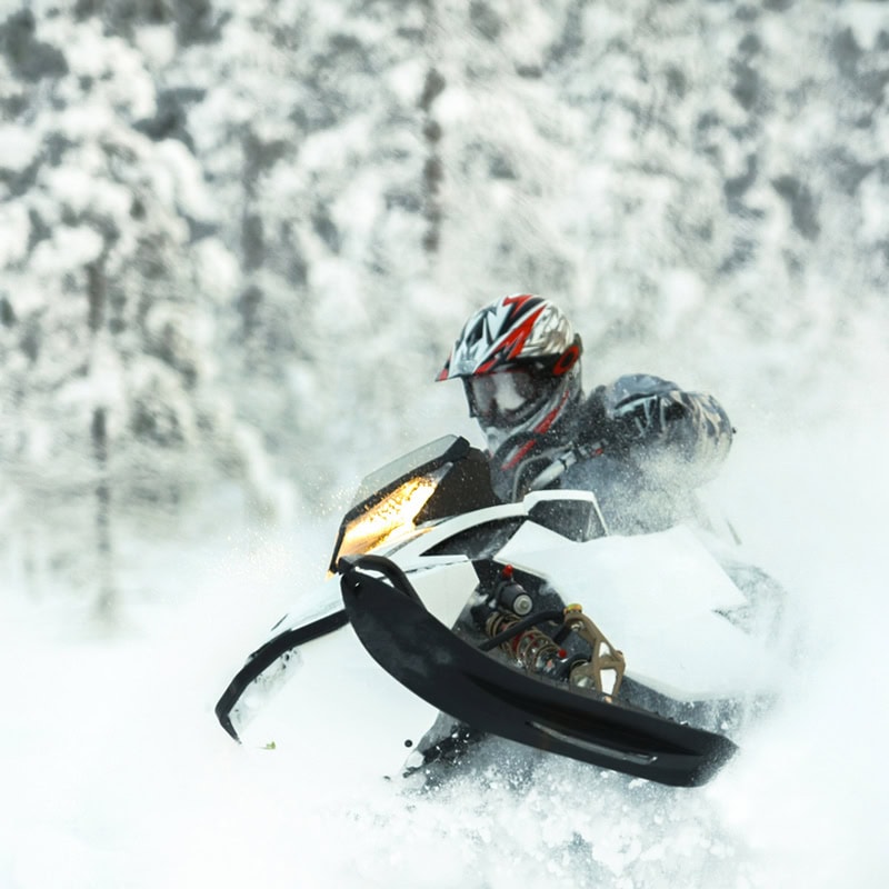 Snow mobile plowing through snow